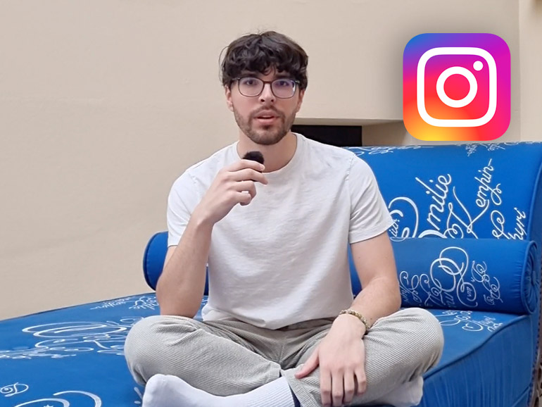 Ein Mann hockt auf dem blauen Sofa im Lichthof