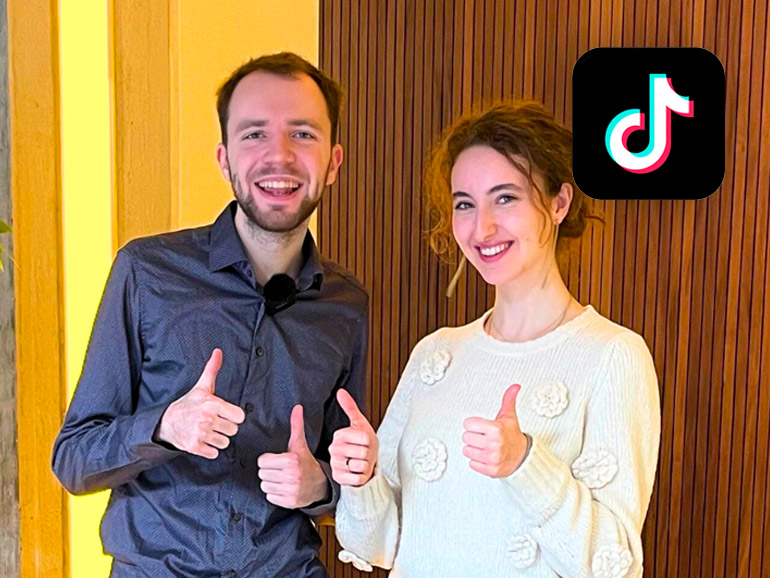 Maximilian Janisch mit einer Studentin. Beide zeigen Daumen hoch mit beiden Händen.